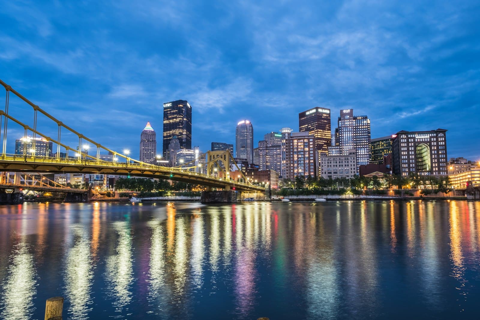 Pittsburgh downtown skyline at night with the Roberto Clemente Bridge reflected in the Allegheny River